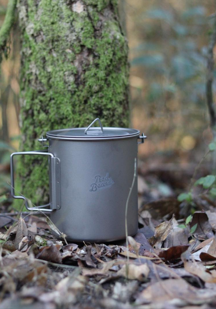 750 mL titanium backpacking pot with lid displayed in a wooded campsite