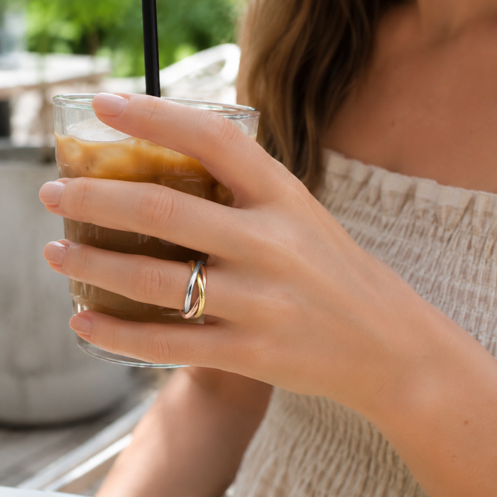 Woman wearing the Willow + Wren Everly Mixed Metal Interlocking Ring at an outdoor Gulf Coast café